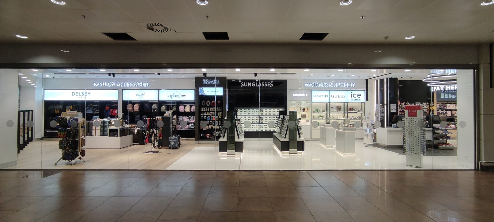 Tiendas de accesorios, gafas y relojes en centro comercial.