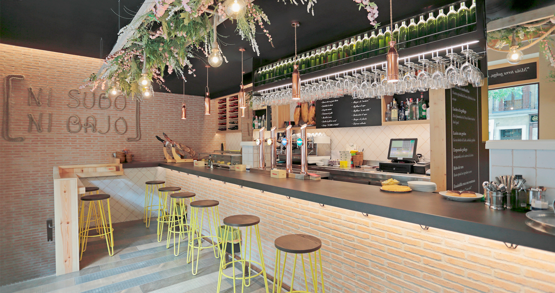 Bar moderno con barra de madera y decoración floral.