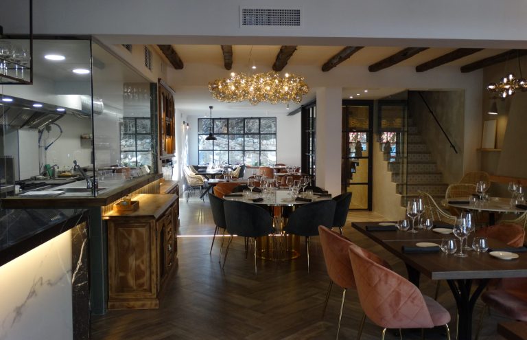 Interior elegante de restaurante con cocina a la vista.