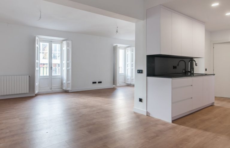 Salón-cocina moderna y luminosa con suelo de madera.