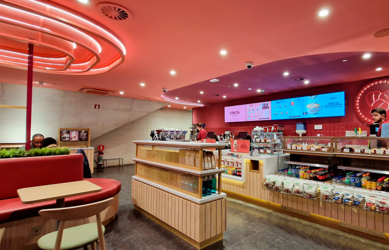Interior moderno de cafetería Costa Coffee con decoración roja.