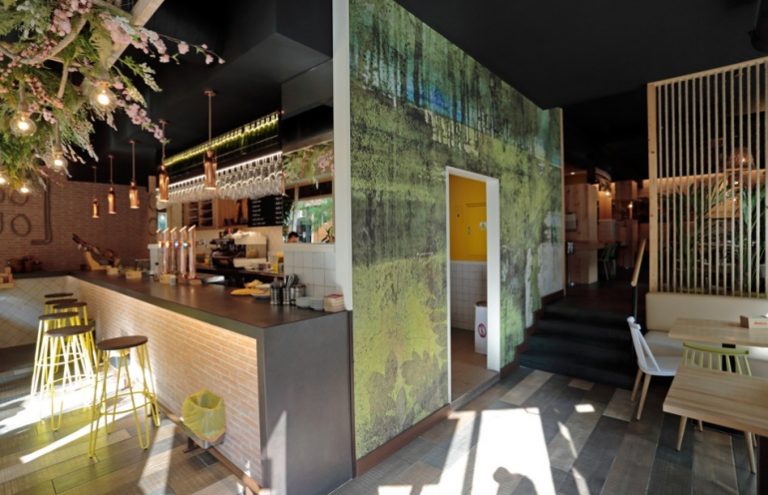 Bar moderno con decoración natural y ambiente acogedor.