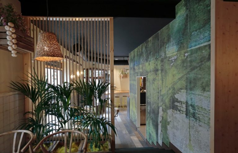 Interior moderno de restaurante con plantas y decoración artística.